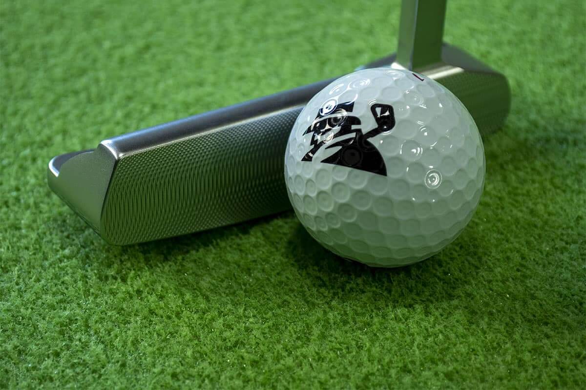 A ball and putter on one of the best indoor putting mats