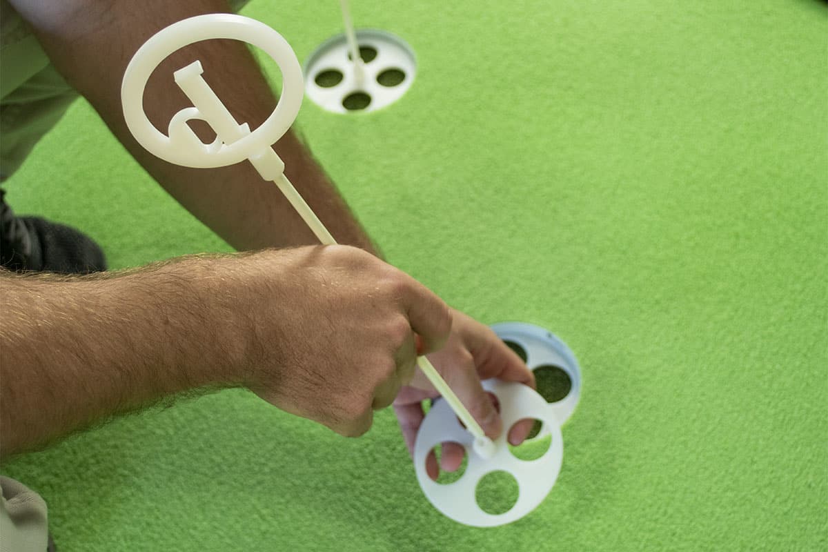 A man working with one of the best indoor putting mats