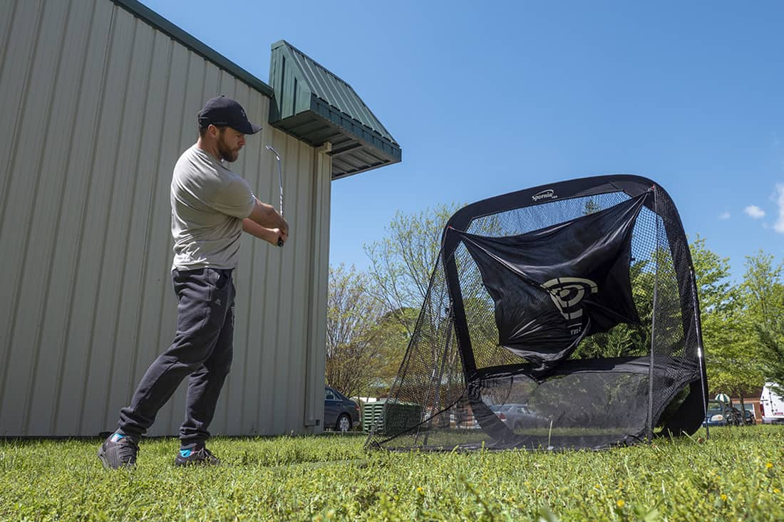 A man swinging into one of the best golf nets