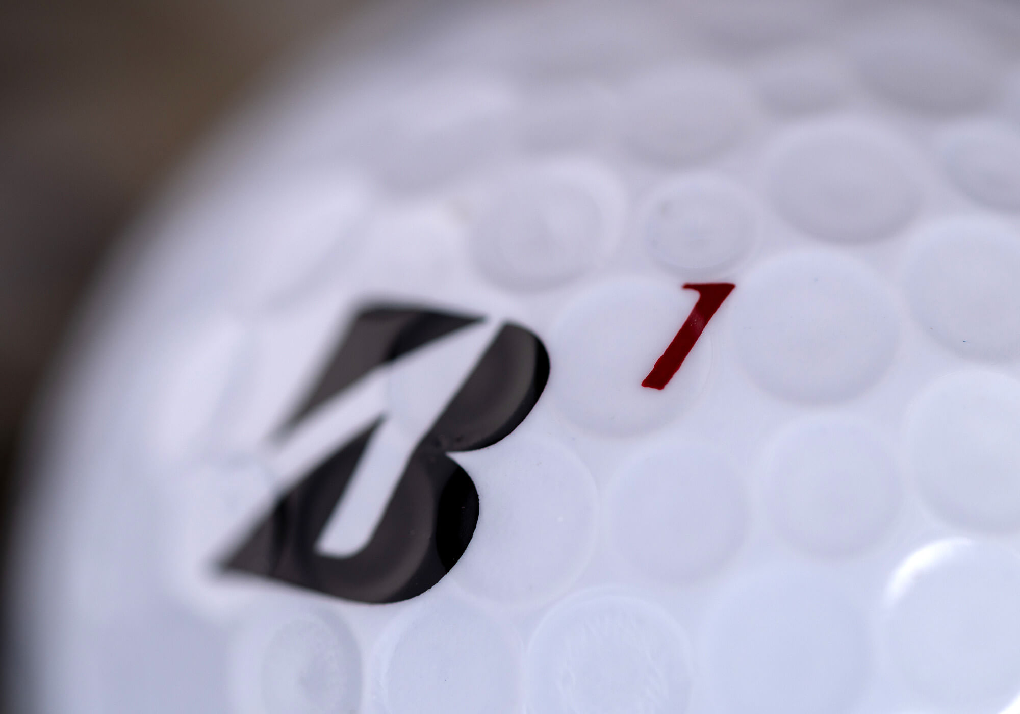 A closeup of the #1 on a Bridgestone TOUR B series golf ball.
