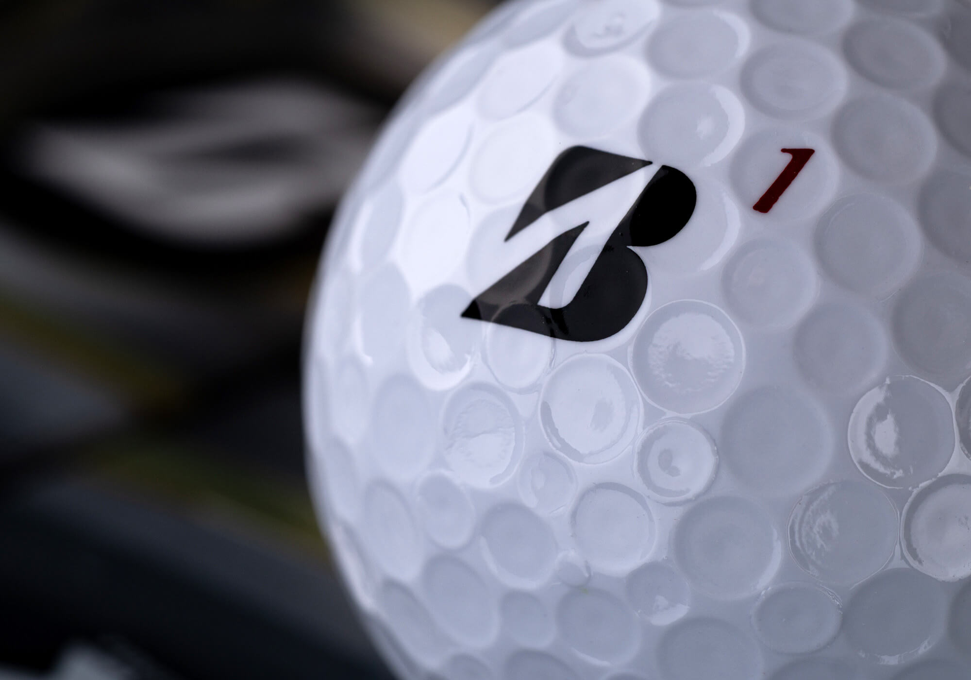 A closeup of the dimples on a Bridgestone TOUR B series golf ball