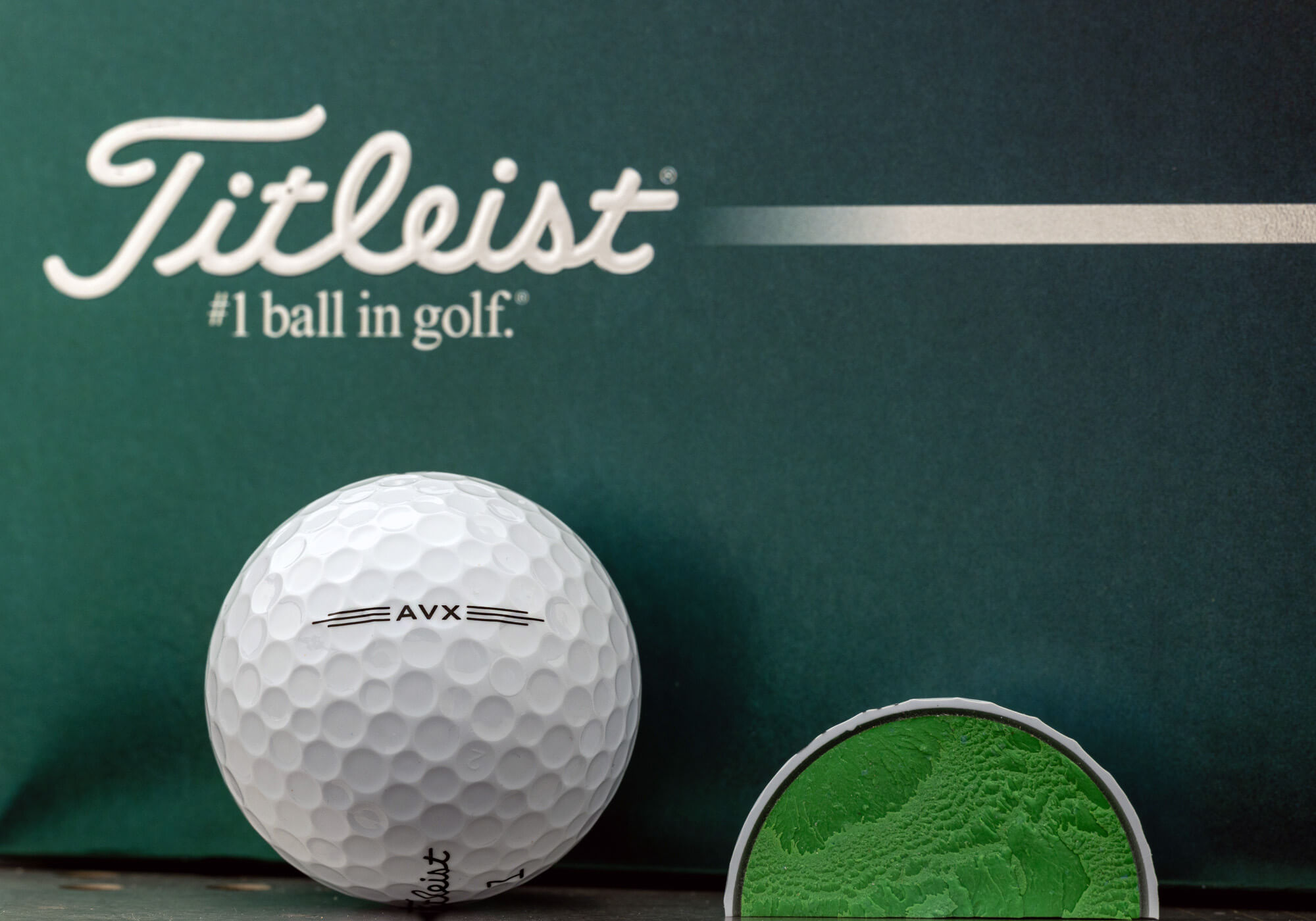 A Titleist AVX ball next to a cut resting on a box