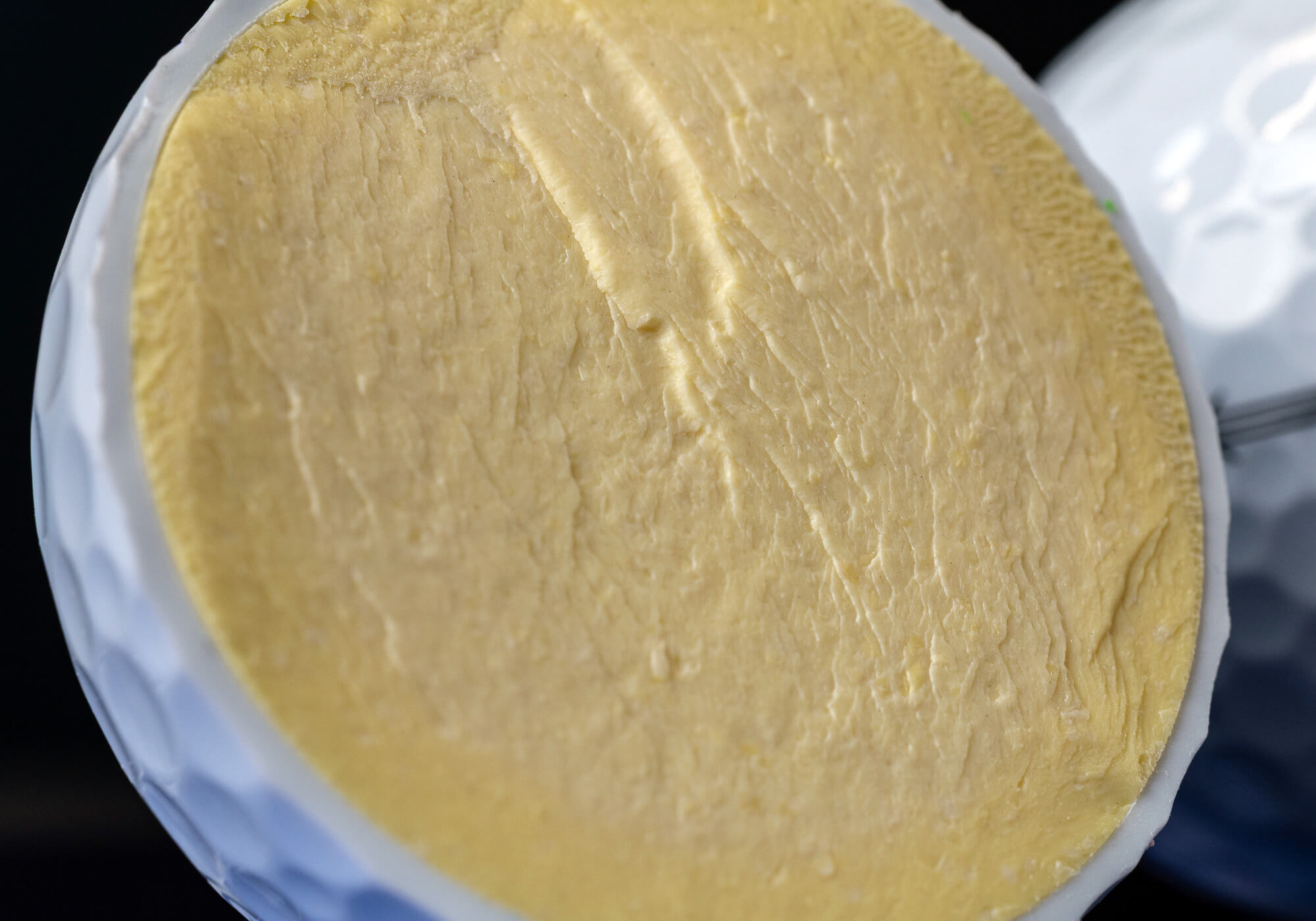 An extreme close-up of the cover of a soft Titleist Tour golf ball