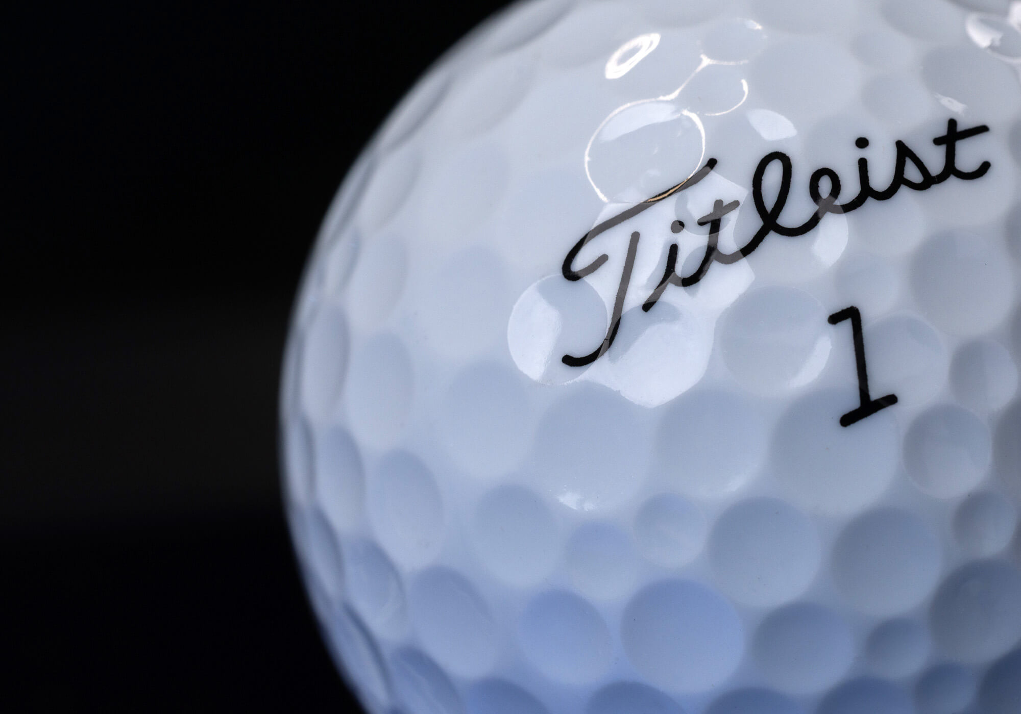 A close-up of the Titleist logo and a dimple on a Tour Soft golf ball