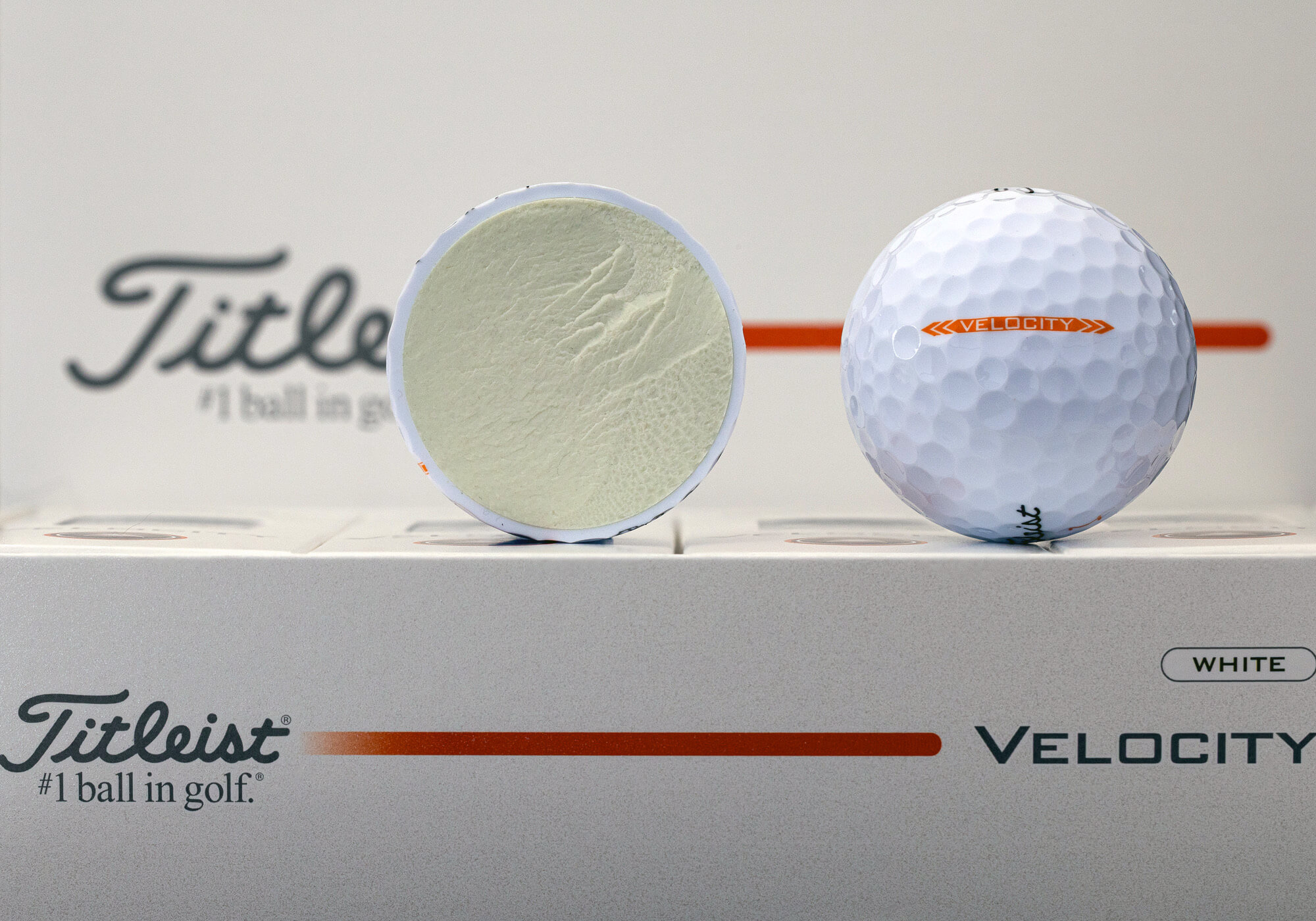 A Titleist Velocity golf ball next to a cutout that reveals the core