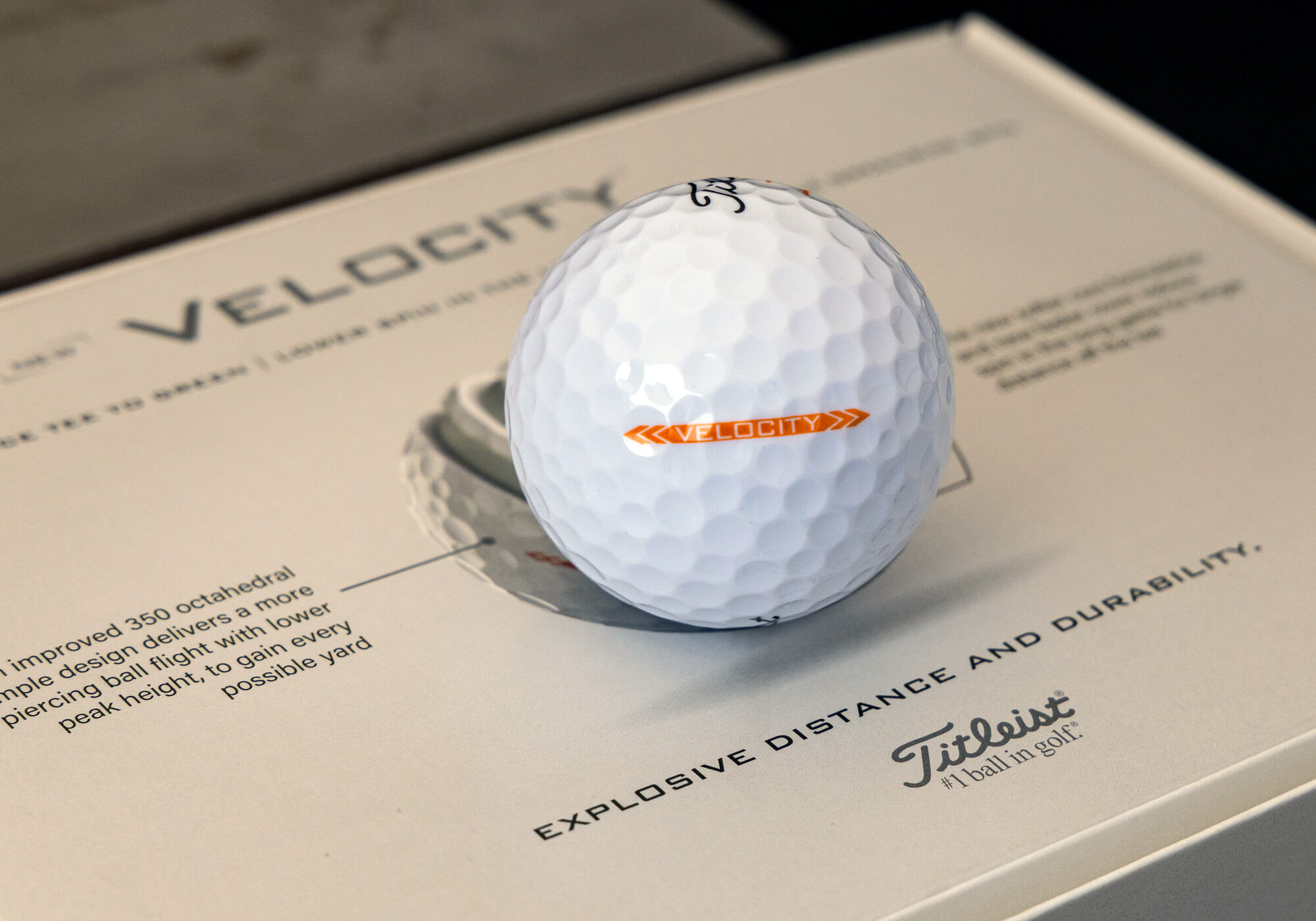 A Titleist Velocity golf ball that rests in a box